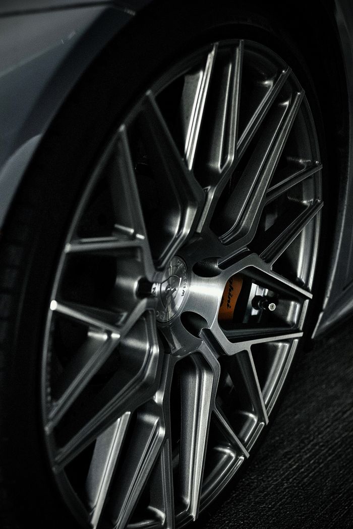 Detailed view of a silver sports car wheel and rim design, emphasizing elegance. splash auto zone