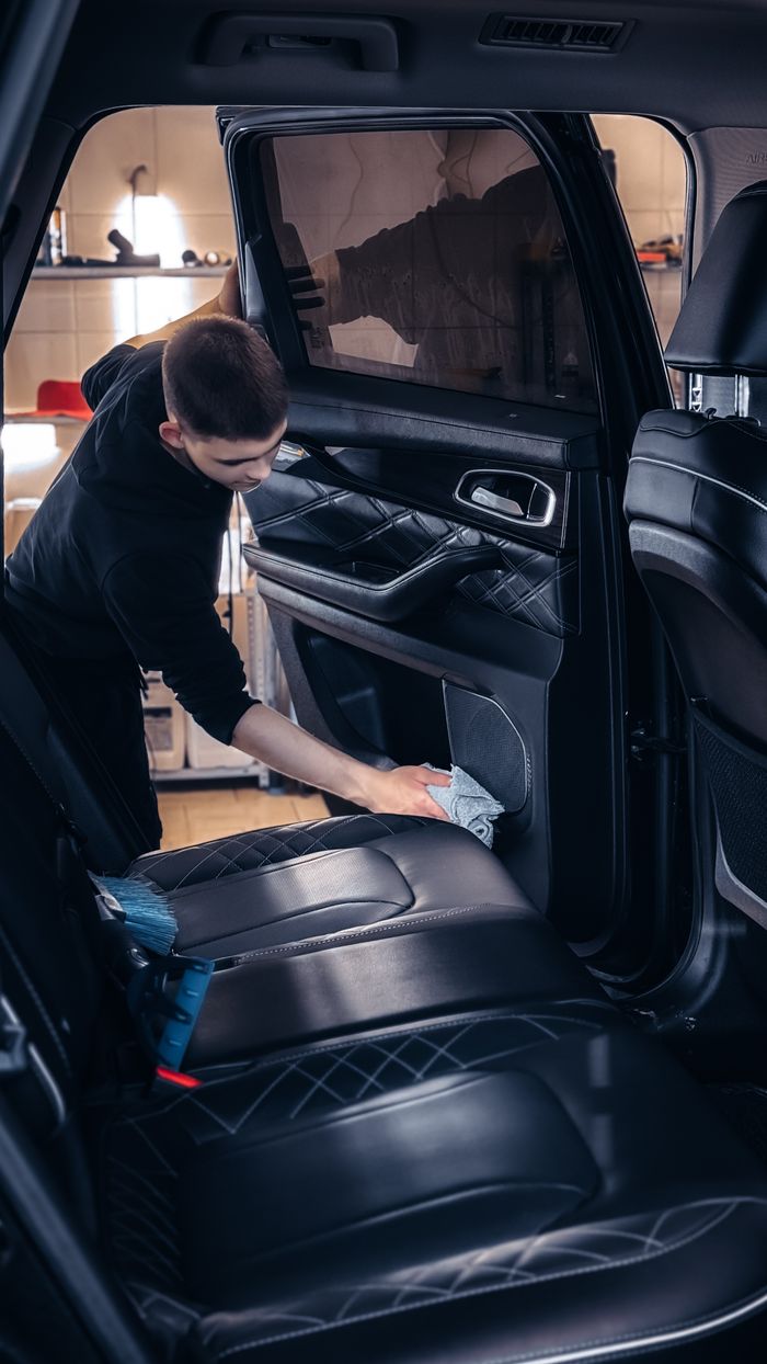 Professional car cleaning service in progress with focus on interior detailing for quality maintenance. splash auto zone car washing and interior cleaning car wash abu dhabi